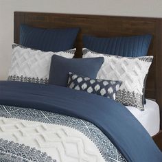 a bed with blue and white pillows on it