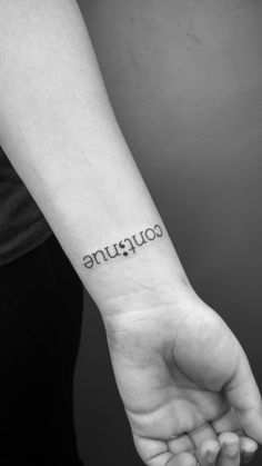 a woman's arm with the word coupaune tattooed on her wrist