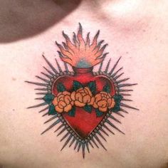 a woman's chest with a heart and flowers tattoo on the back of her neck