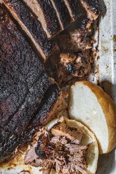 a roast beef sandwich is cut into slices and placed on a plate with some bread