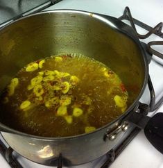 a pot filled with food sitting on top of a stove next to a burner