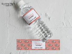 a bottle of water sitting on top of a table next to a label with an elephant design