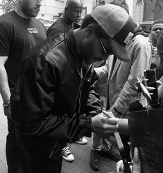 a man signing autographs for fans at an event