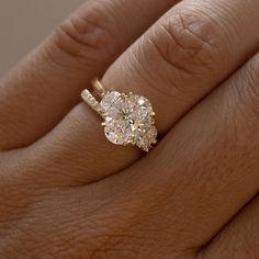 a woman's hand with a diamond ring on top of her finger and an engagement band