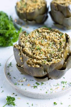 stuffed artichokes on a plate with parsley sprinkled in seasoning