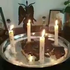 a cake with lit candles sitting on top of a glass plate covered in icing