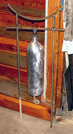 an old fashioned fire extinguisher hanging from a rope in front of a wooden wall