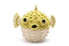 a crocheted yellow and white stuffed animal with several other items around it, including the head