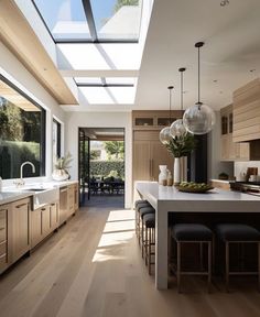 an open kitchen and dining room area with skylights above the countertop, along with wooden flooring