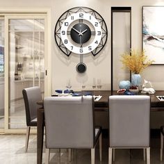 a dining room table with chairs and a clock on the wall in front of it