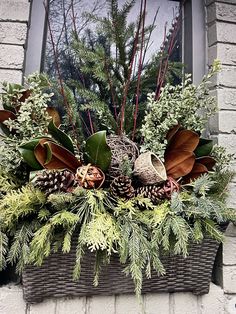 a window box filled with plants and pine cones