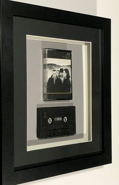 an old fashioned cassette player is framed in a black and white frame with the image of three people on it