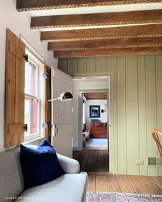 a living room filled with furniture next to a wooden floor and ceiling mounted light fixture