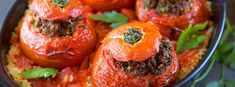 some stuffed peppers are in a bowl with parsley on the top and green garnish