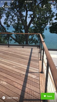 a wooden deck overlooking the water and trees