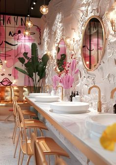 a bathroom with two sinks and mirrors on the wall next to each other in front of flowers