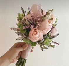 a person holding a bouquet of flowers in their hand