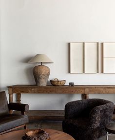 a living room with a table, chair and lamp