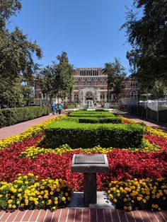 a garden with many different flowers and plants in the center, surrounded by brick walkways