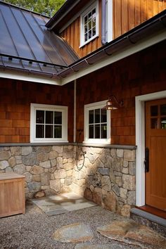 a house with two doors and windows on the side of it, next to a stone walkway