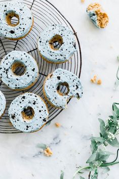 donuts with blue icing and sprinkles on a wire rack