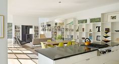 an open living room and dining area with bookshelves