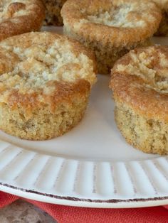 several muffins on a white plate sitting on a red and white table cloth