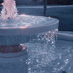 a fountain with water spouting from it's sides in the evening sun