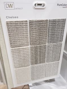 the back side of a display case with white and gray squares on it, in front of other boxes