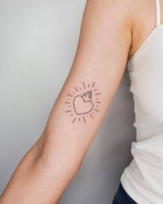 a woman's arm with a tattoo on it that has a lightbulb in the shape of a heart