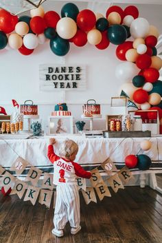 a little boy standing in front of a cake table