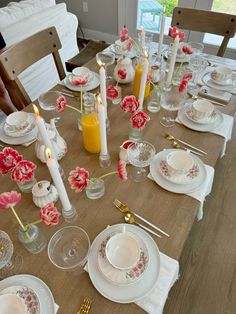 the table is set with plates, silverware and candles