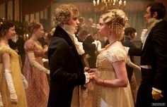 a man and woman in period dress talking to each other at a ball or formal event