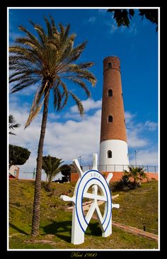 a large white and blue sculpture next to a palm tree