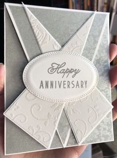 someone is holding up a card that says happy anniversary with an ornament on it