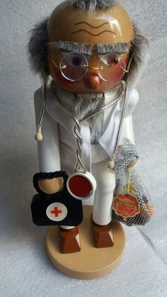 an old fashioned doctor doll with glasses and a stethoscope in his hand