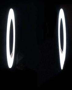 two circular lights in the dark with one light turned on and the other illuminated off