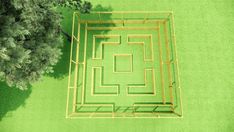 an aerial view of a square maze in the middle of a grassy area next to a tree