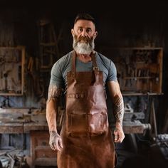 a bearded man wearing an apron in a workshop