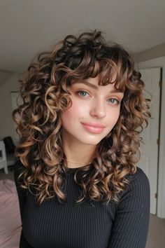 Curly haircuts are all about celebrating your texture and finding a style that complements your face shape. Whether you have loose waves, bouncy spirals, or tight coils, there’s a curly haircut out there that will 3b Curly Hair Shoulder Length, Curly Hair Cuts Bangs, Curly Hair Round Face Haircuts, Medium Length Curly Hair With Bangs, 70s Curly Hairstyles, Curly Hair Styles With Bangs, Edgy Curly Haircut, Curly Fringe Bangs, Perfect Curly Hair