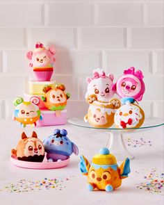 there are many small toy animals on the table with cupcakes and sprinkles