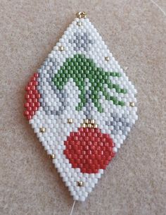 a white beaded ornament with red, green and white flowers on it