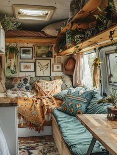 the inside of a camper with lots of plants and pictures on the wall above it