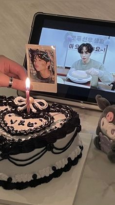 a person holding a lit candle in front of a cake