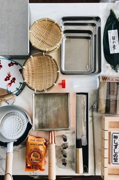 various kitchen utensils are laid out on a counter top, including baking pans and spatulas