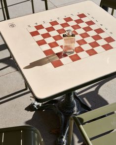 a chess board on top of a table with a knife sticking out of the checkerboard