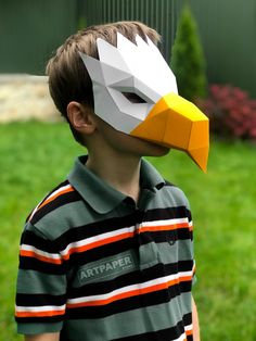 a young boy wearing an eagle mask on his face