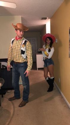 two people dressed up in costumes standing next to each other and one is wearing a cowboy hat