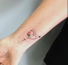 a woman's arm with a small heart tattoo on the left side of her wrist