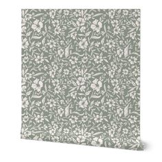 a green floral wallpaper with white flowers and leaves on the side, in front of a